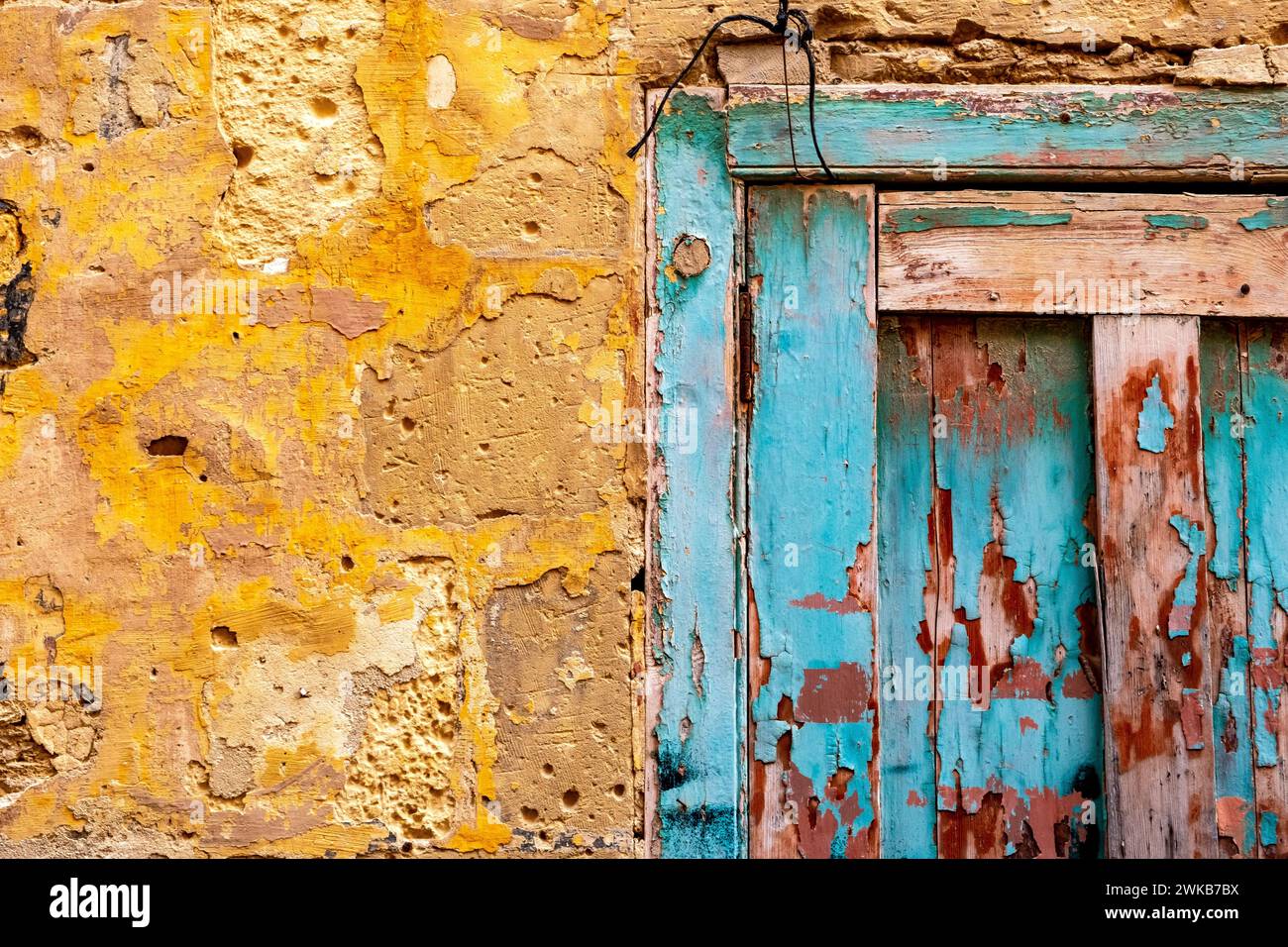 Türkisfarbene Tür und gelbe Wand an einem alten leeren Haus in Malta Stockfoto