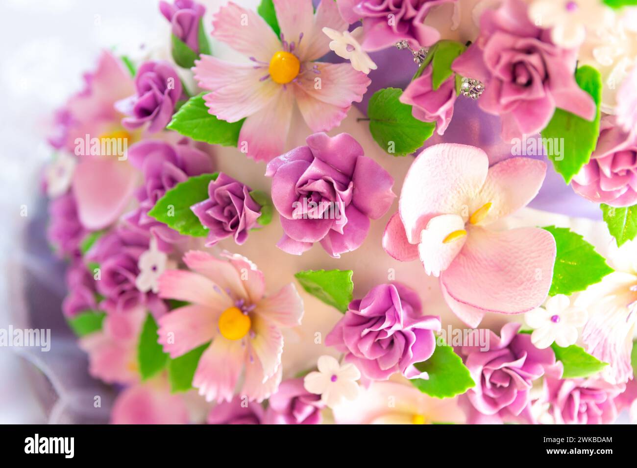 Tortendekoration. Wunderschöne Hochzeitstorte mit lila Orchideen. Kuchen in violetten Tönen Stockfoto