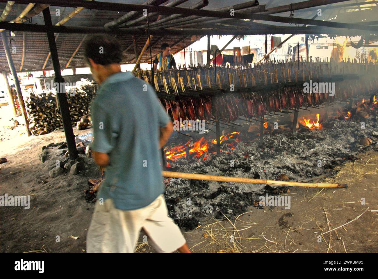 Eine geräucherte Fischproduktion, bei der Bonito-Thunfischfleisch in einer heimischen Industrie in Bitung, Nord-Sulawesi, Indonesien, verwendet wird. Der Beitrag indigener Wissens zur technologischen Innovation bietet laut dem Bericht des Zwischenstaatlichen Ausschusses für Klimaänderungen (IPCC) aus dem Jahr 2023 eine breite Palette von Optionen für das Management unter anderem der Ernährungssicherheit. Der im Volksmund als Cakalang Fufu bekannte geräucherte Thunfisch gilt als exotisches einheimisches Lebensmittel und könnte eine alternative Lösung für den Umgang mit den Auswirkungen des Klimawandels auf den Ozean werden. Stockfoto