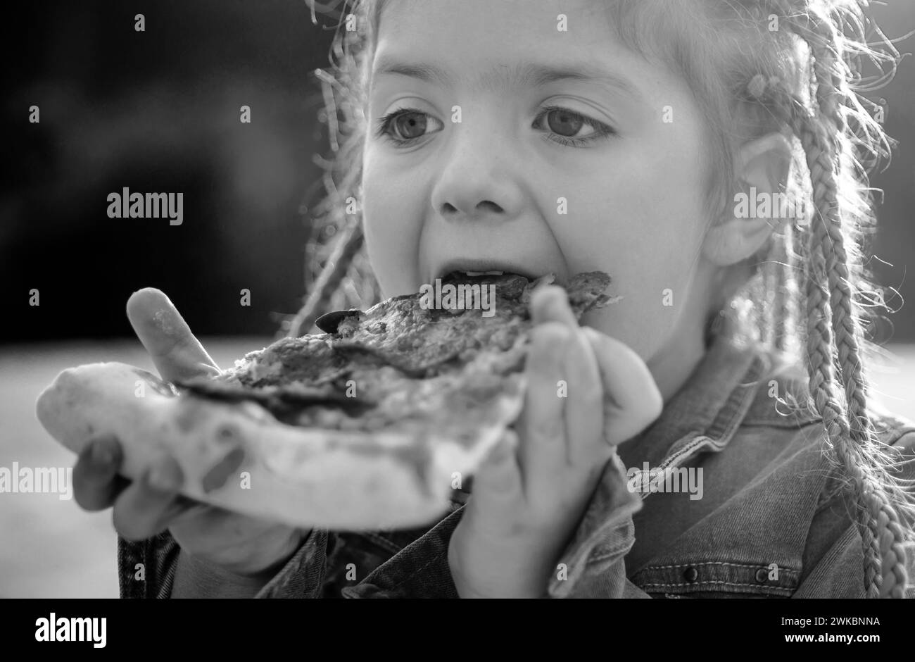 Kinder lieben Essen. Leckere Pizza. Kinder essen Pizza. Fastfood. Italienisches Junkfood. Kleines Mädchen, das im Freien zu Mittag gegessen hat. Stockfoto