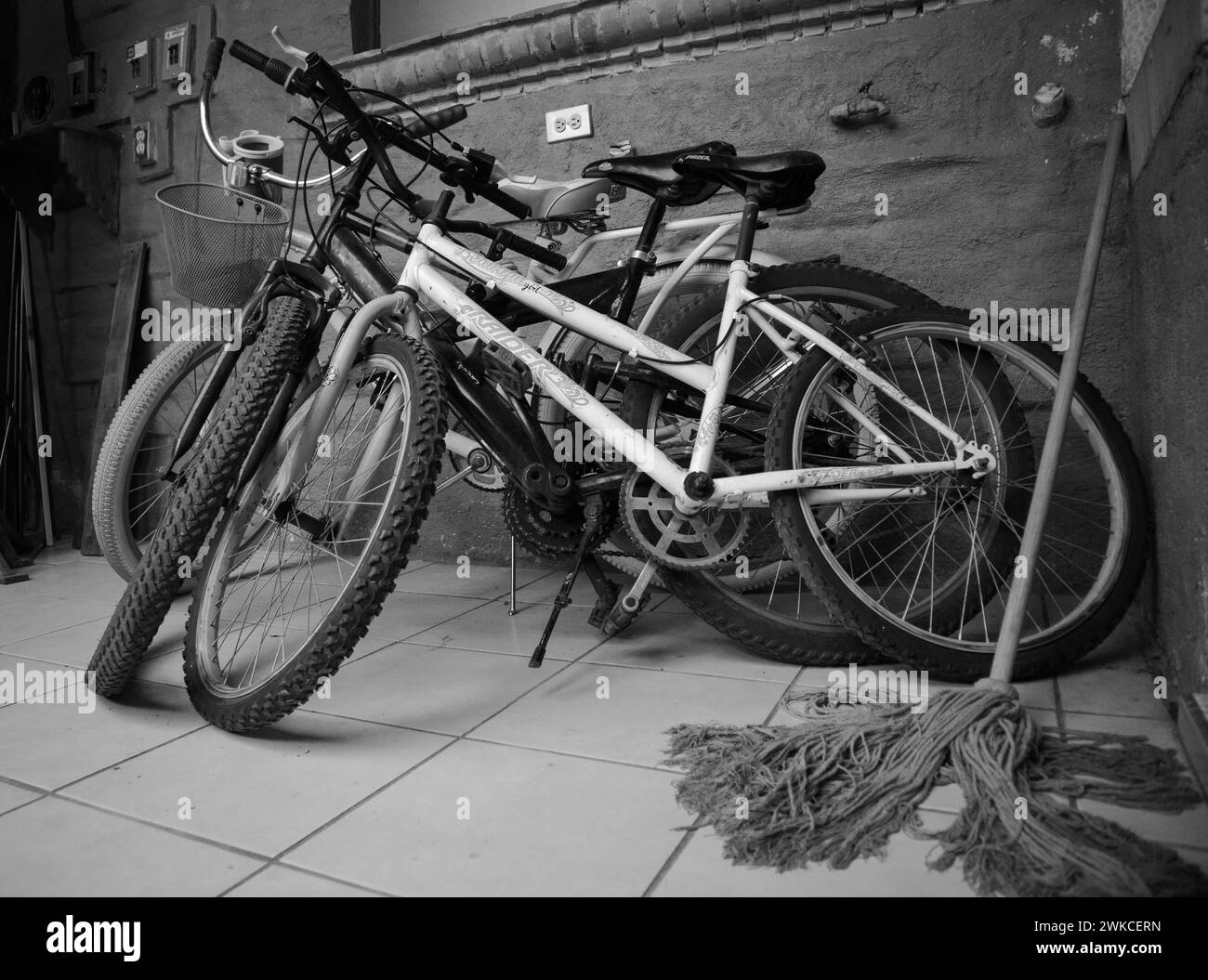 Fahrräder und Wischmopp in einem Versorgungsraum. Stockfoto