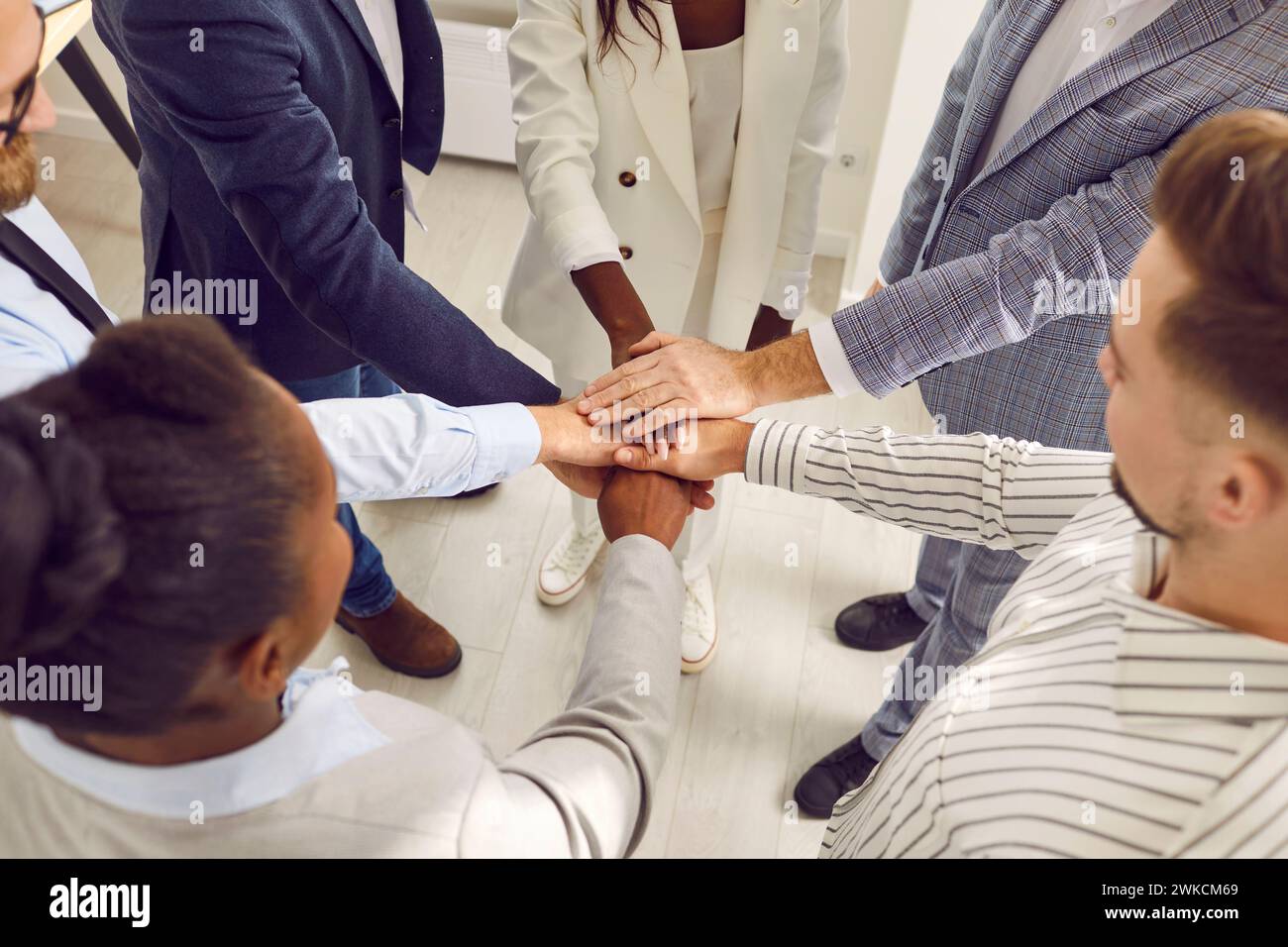 Motivierte Geschäftsleute, die Hände zusammenlegen, Ansicht von oben Stockfoto