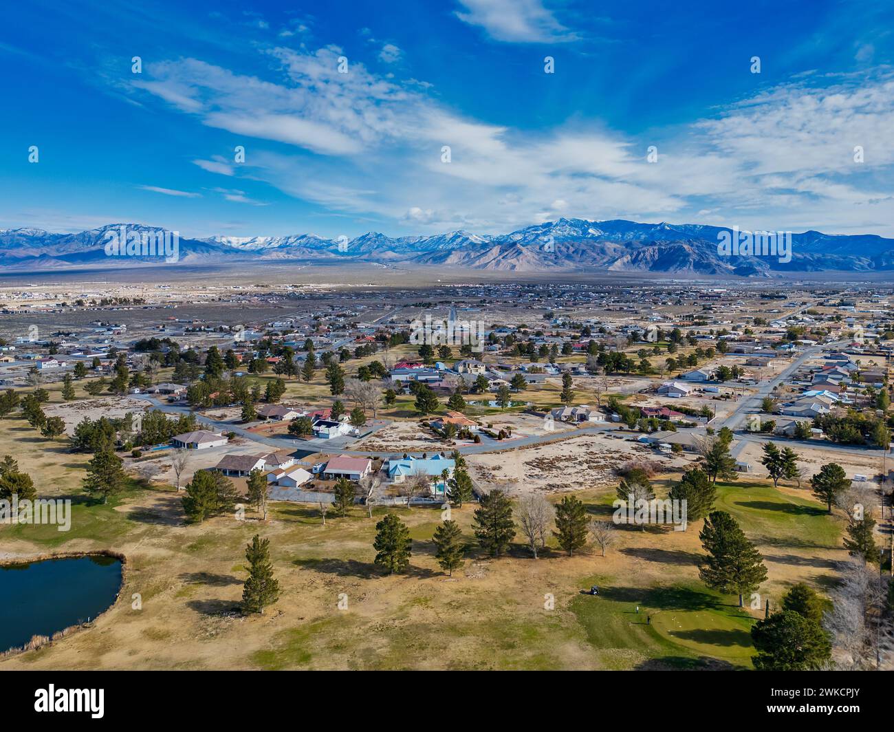 Ein Blick aus der Vogelperspektive auf Pahrump, Nevada, eine halbländliche Stadt, die sich in Richtung schneebedeckter Berge ausdehnt. Stockfoto