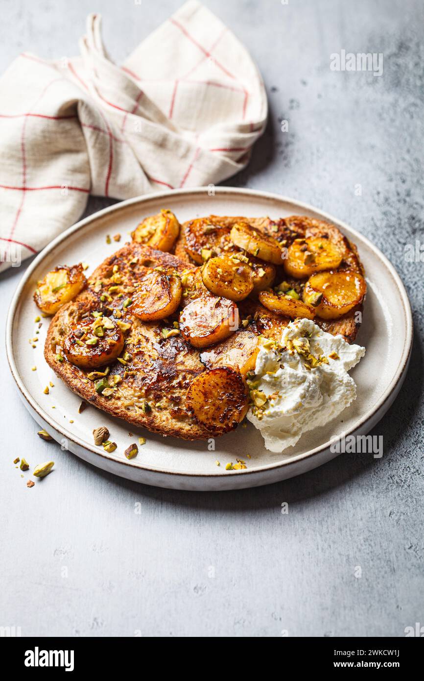 Französische Toasts mit karamelisierten Bananen und Pistazien. Stockfoto