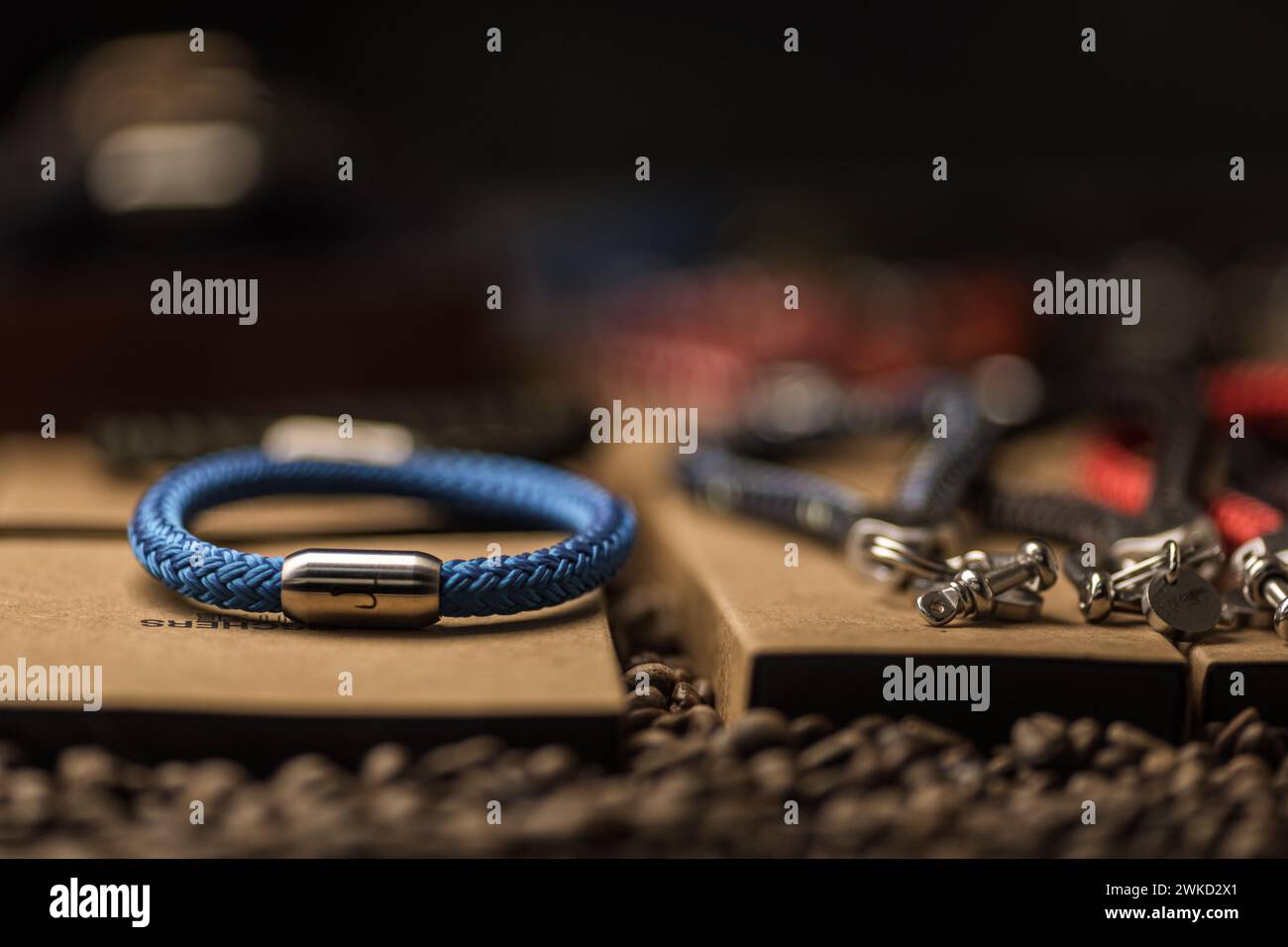 Ein blaues Armband mit einem Ankersymbol in einem Geschäft. Es gibt noch andere Souvenirs und Accessoires. Kaffeebohnen als Dekoration Stockfoto