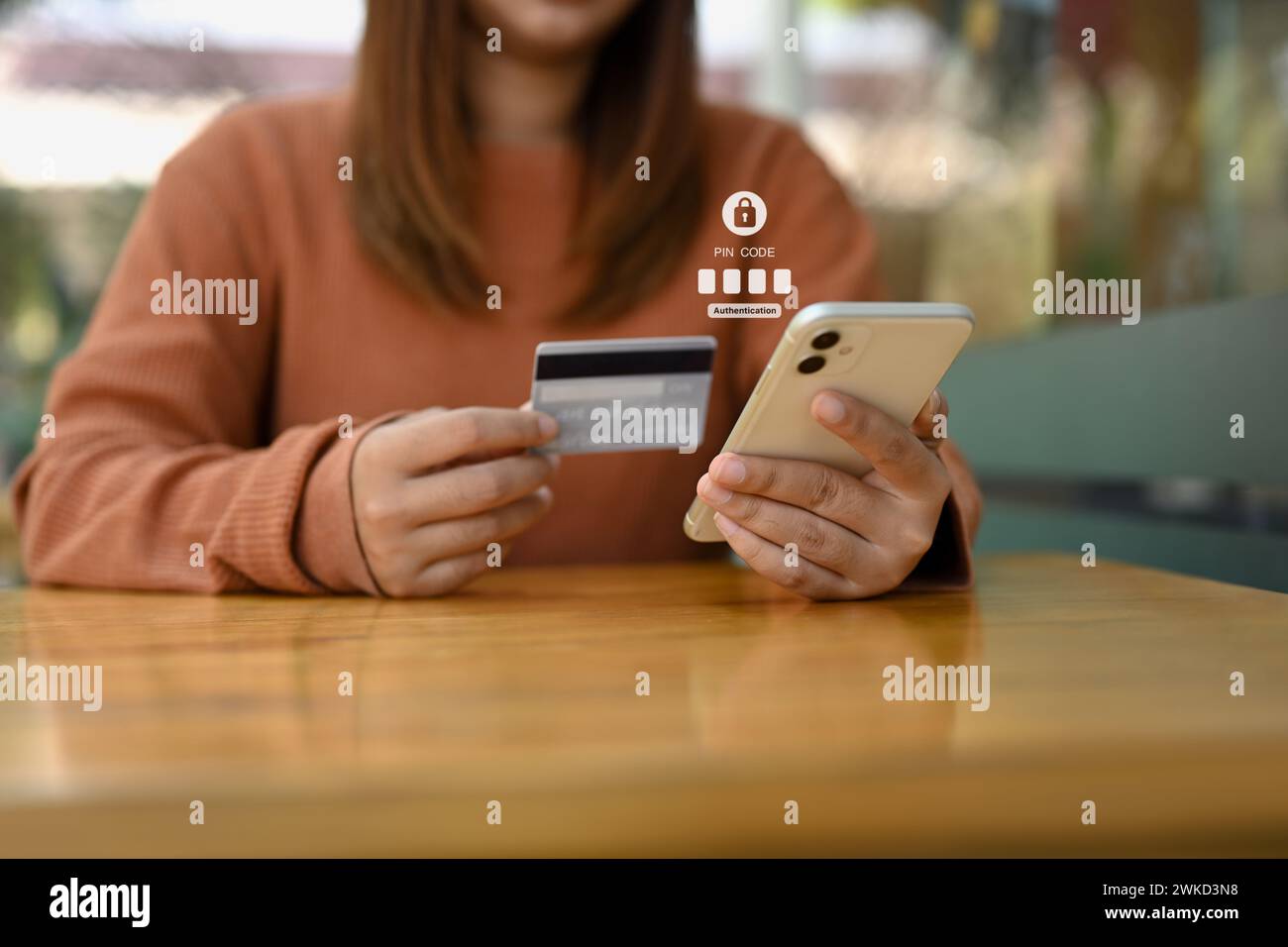 Junge Frau mit Kreditkarte und Eingabe des Verifizierungscodes auf das Online-Bankkonto Stockfoto