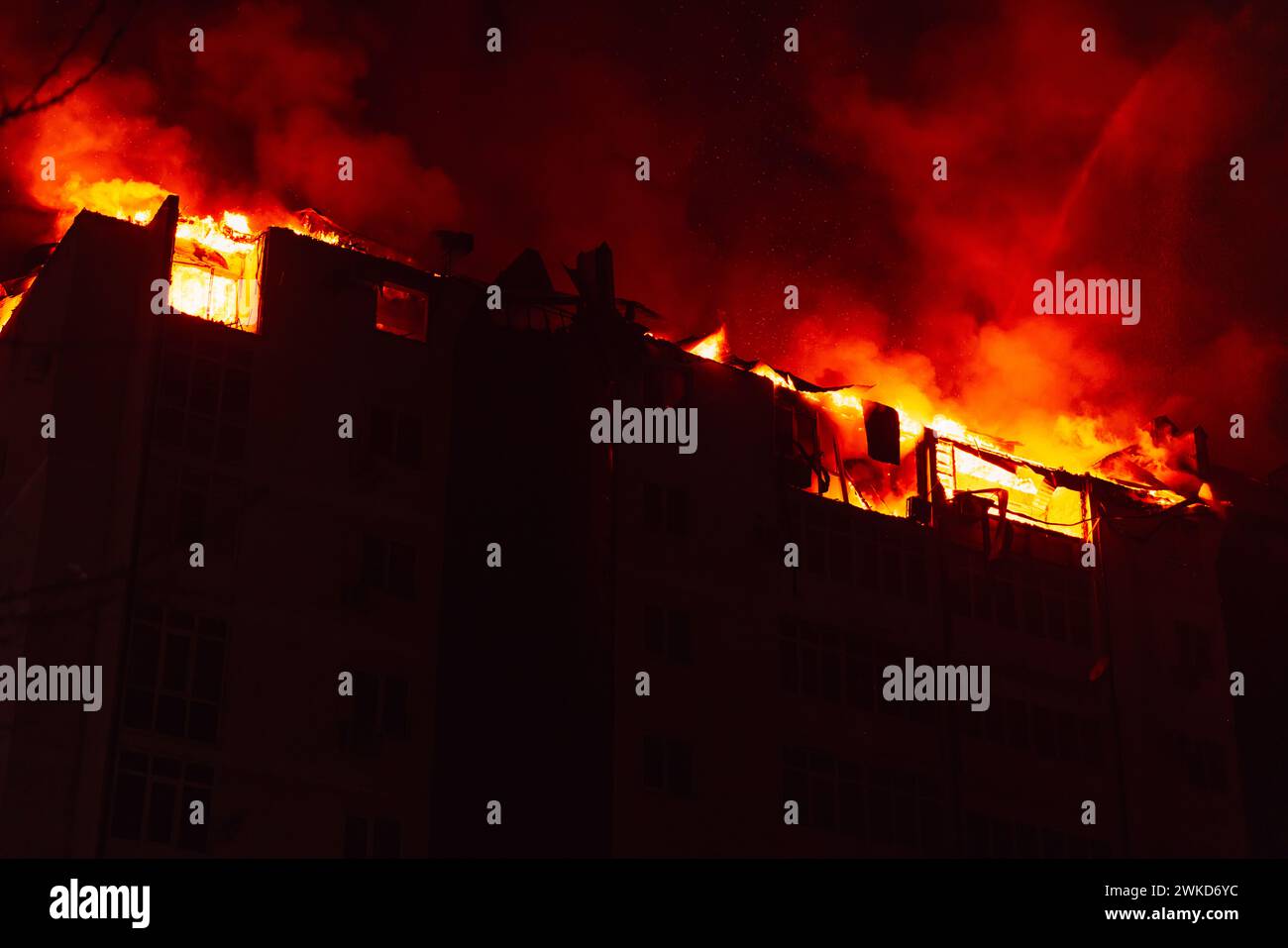 Ein riesiges Feuer brannte in einem mehrstöckigen Wohnhaus. Brennendes Haus ist nachts in Flammen verwickelt während der Katastrophe Stockfoto