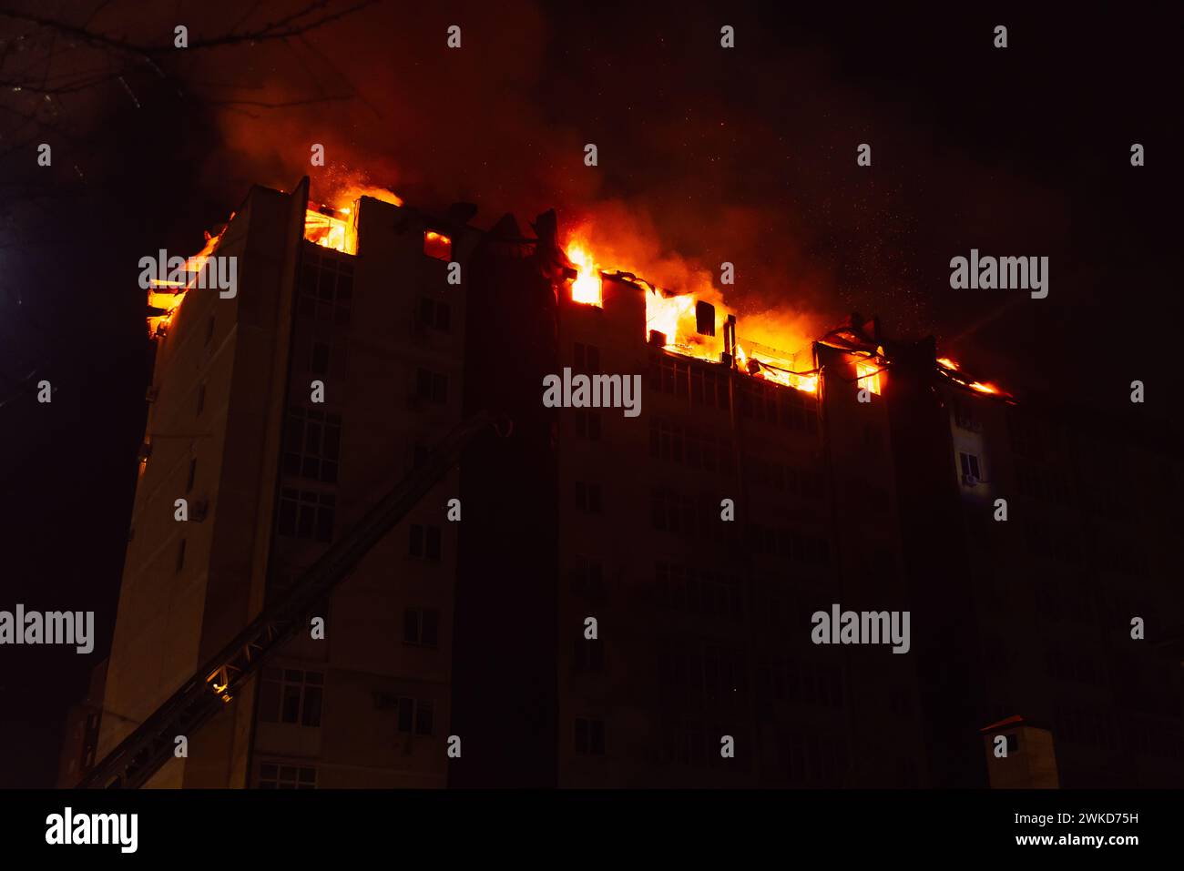 Ein riesiges Feuer brannte in einem mehrstöckigen Wohnhaus. Brennendes Haus ist nachts in Flammen verwickelt während der Katastrophe Stockfoto