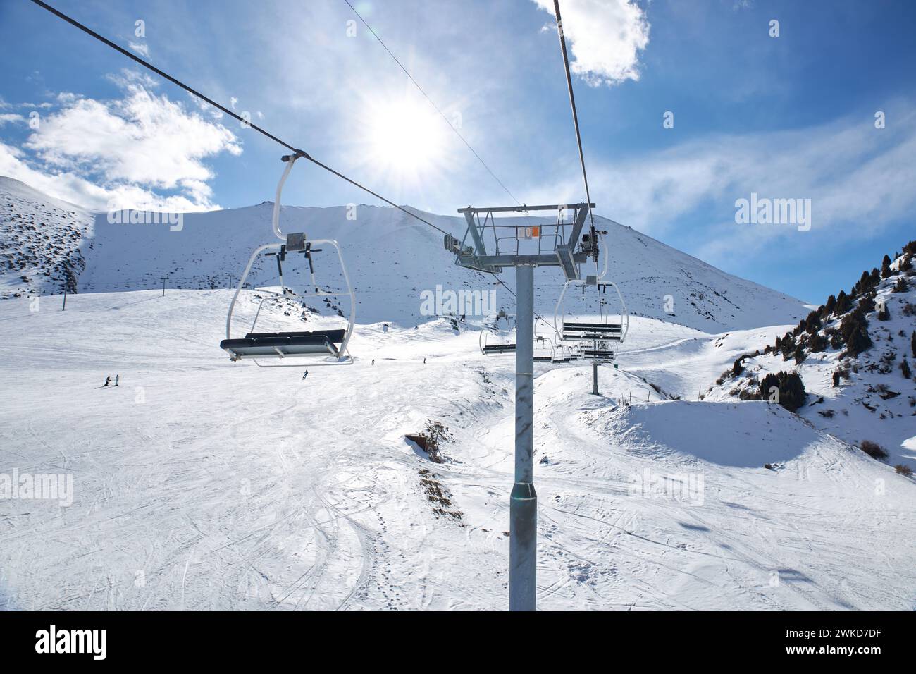 Skigebiet Chunkurchak in Kirgisistan. Leeren Sie die Sitze im Skilift. Berghang am sonnigen Wintertag, blauer Himmel. Aktive Erholung Skifahren und Snowboarden. S Stockfoto