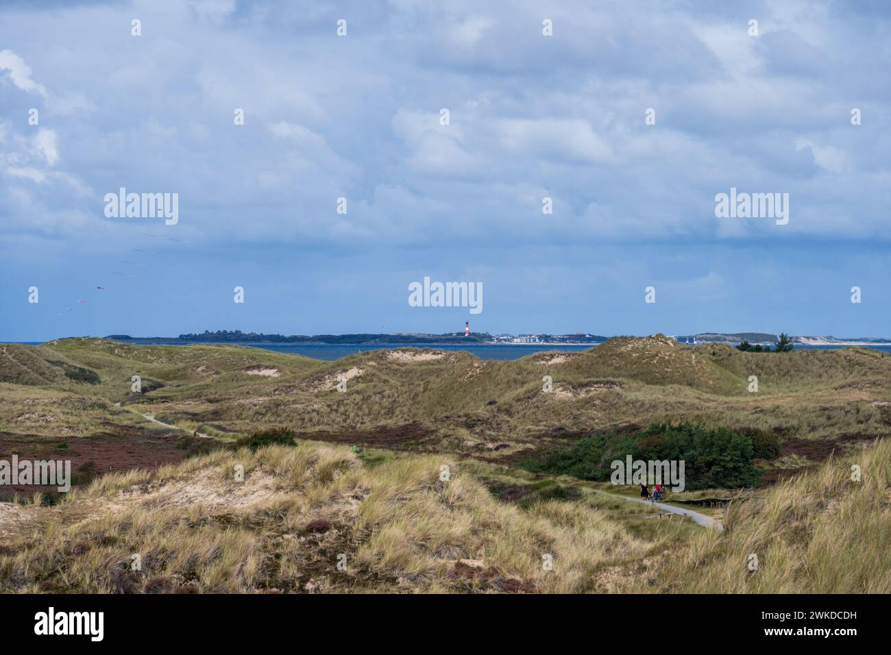 Dramatische Wolken im Dünenbereich der Nordseeinsel Amrum der Blick geht hinüber zur Nachbarinsel Sylt mit dem Leuchtturm von Hörnum Stockfoto