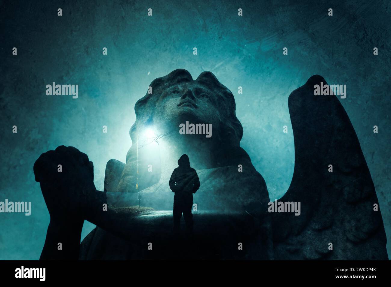 Eine doppelte Exposition einer Engel-Statue auf dem Friedhof, die betet. Mit einer gruseligen Kapuzenfigur. Nachts auf einer Straße stehen. Mit einer Grunge-Bearbeitung Stockfoto