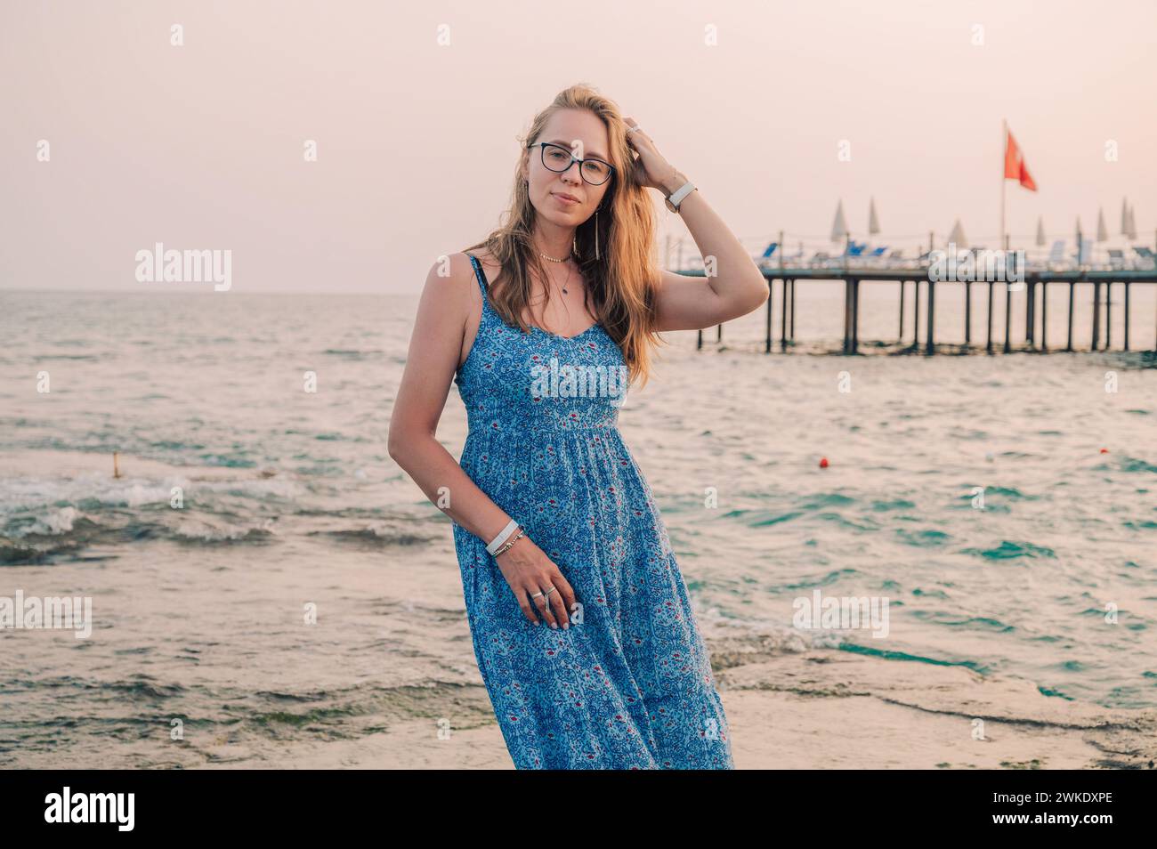 Frau sitzt am Strand und schaut auf das Meer in Alanya, Türkei. Reise- oder Urlaubskonzept Stockfoto