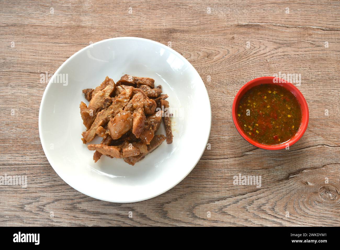 Gedämpfte Scheibe süßes Schweinefleisch auf Teller mit würziger Chili-Sauce Stockfoto