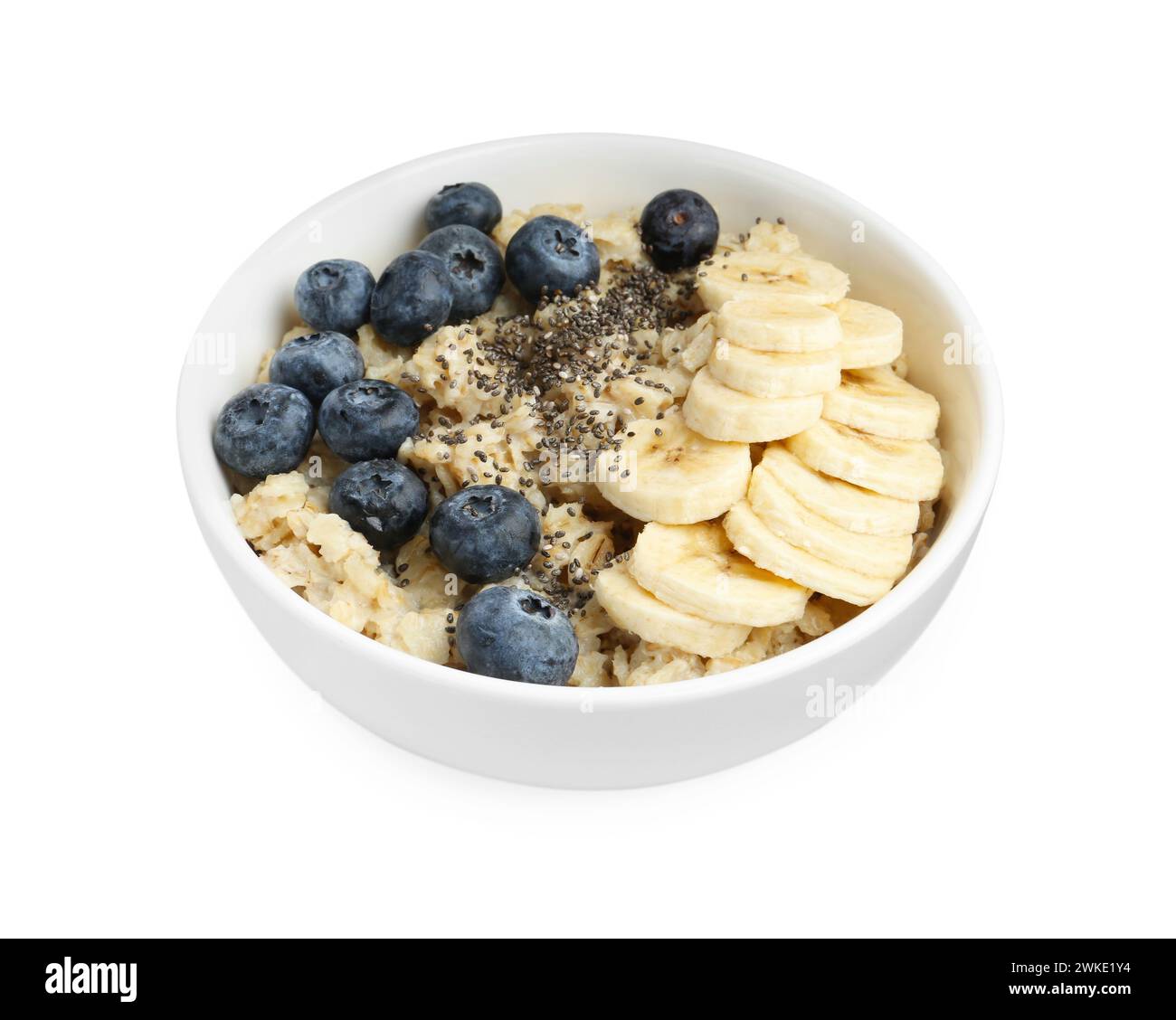 Leckeres Haferflocken mit Bananen, Heidelbeeren und Chiasamen in Schüssel isoliert auf weiß Stockfoto