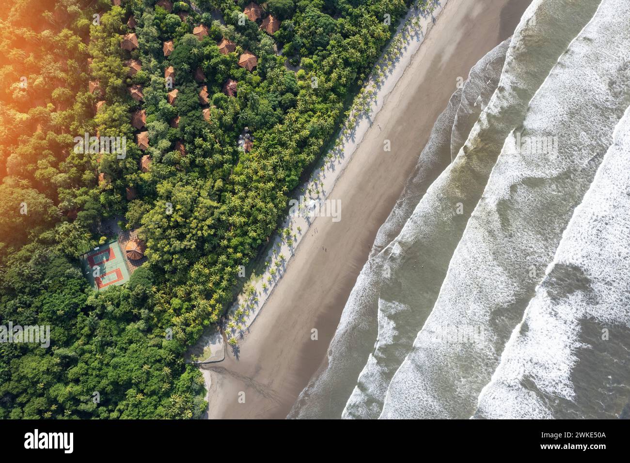 Saubere Strandküste mit Villa und Tennisplatz aus der Vogelperspektive über der Drone Stockfoto