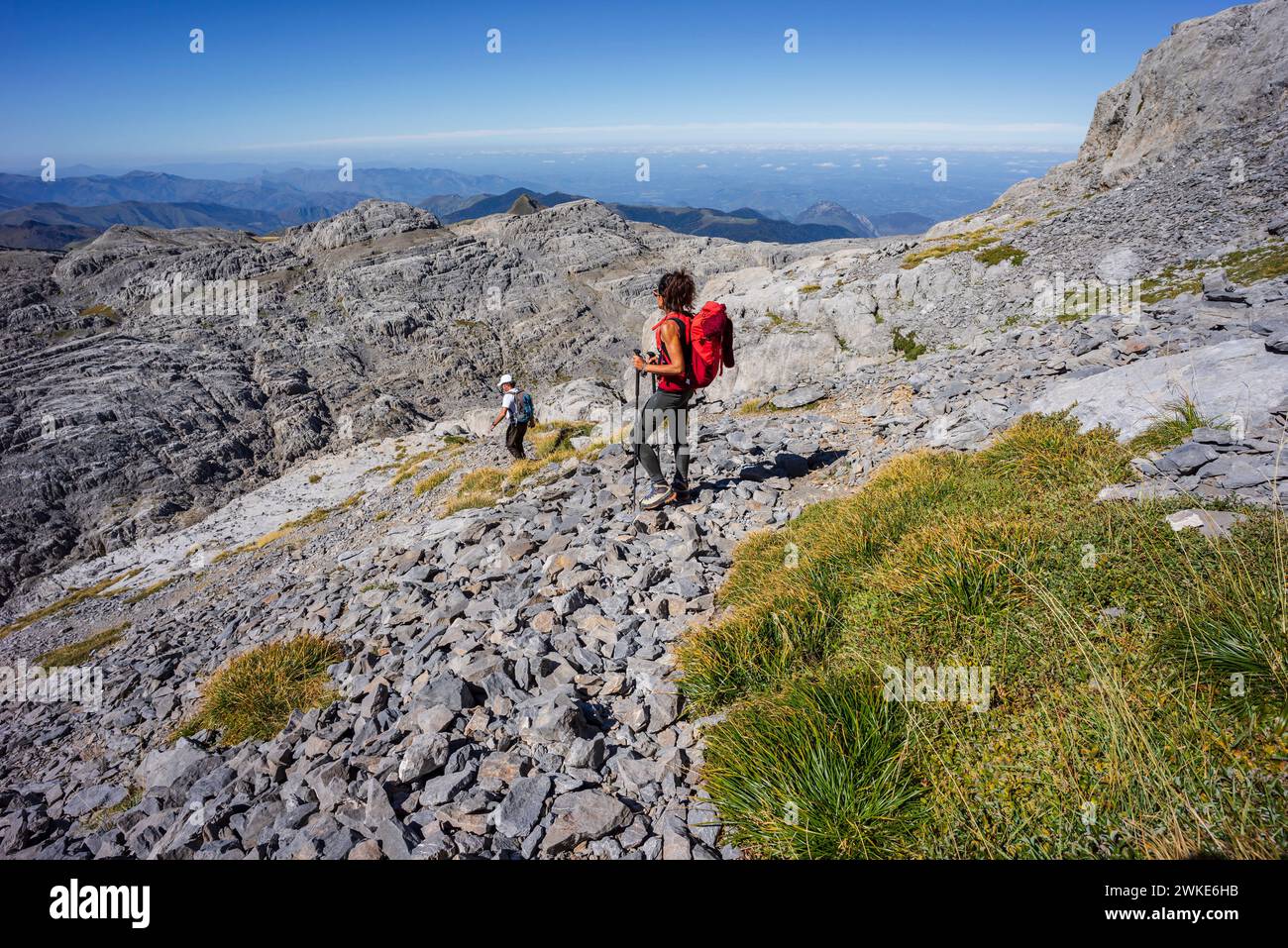 Wanderer, der durch das Kalksteinrelief des Arres de Anie, den Gipfel von Anie, das Kalkplateau von Larra, die Navarra-französischen Pyrenäen, Navarra, Spanien. Stockfoto