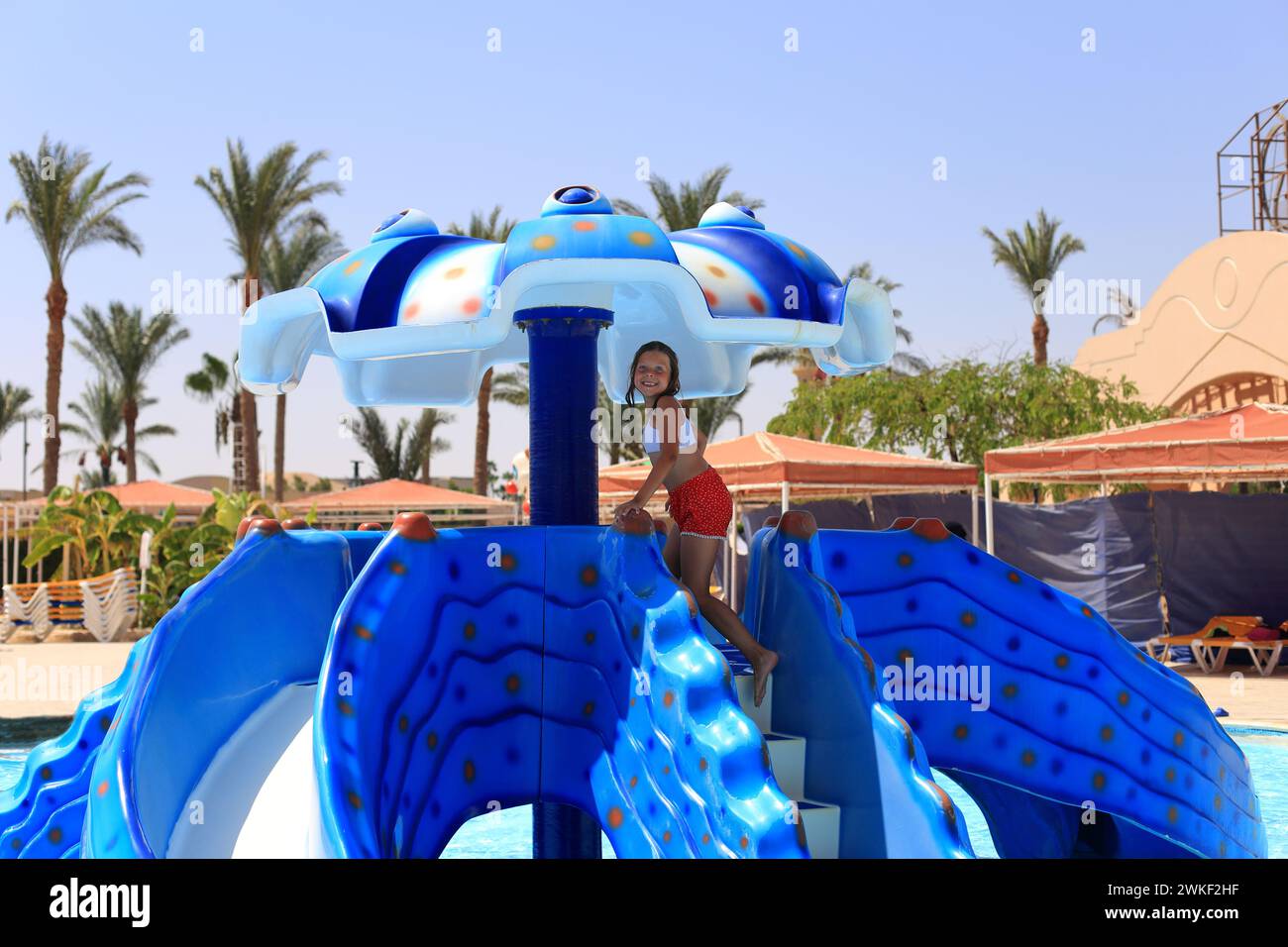 Kleines Mädchen auf einer Rutsche in einem Wasserpark im Sommer. Kind kann im Freiluft-Wasserpark übernachten Stockfoto