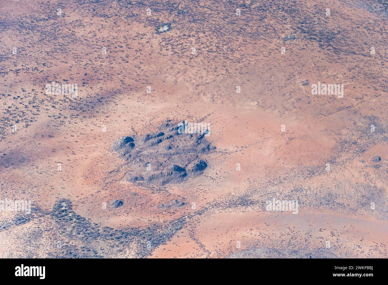 Luftlandcape mit Basalt-Felsblöcken in der Wüste, aufgenommen aus einem Segelflugzeug in hellem Licht des späten Frühlings in der Nähe von Kamkam, Namibia, Afrika Stockfoto