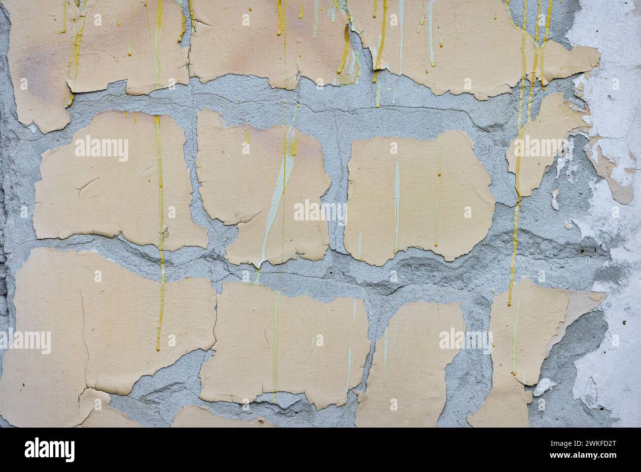 Große gelbe Flecken von alter Farbe auf verwittertem grauen Beton. Die Wirkung zerstört. Stockfoto