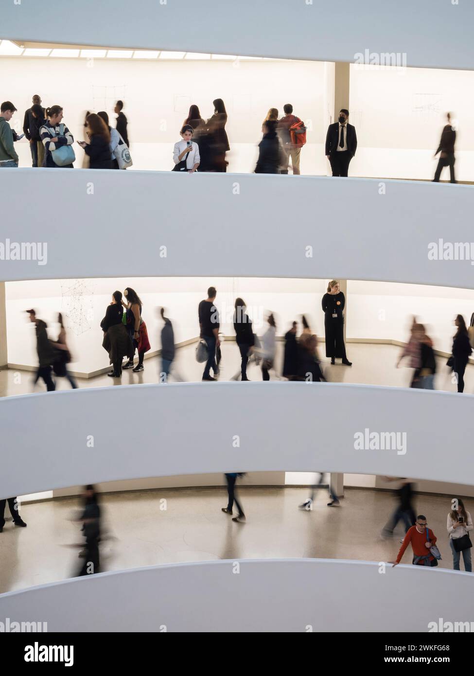 New York, USA - 30. April 2023: Silhouetten von Besuchern im New York Guggenheim Museum auf dem spiralförmigen Fußweg des Museums. Stockfoto