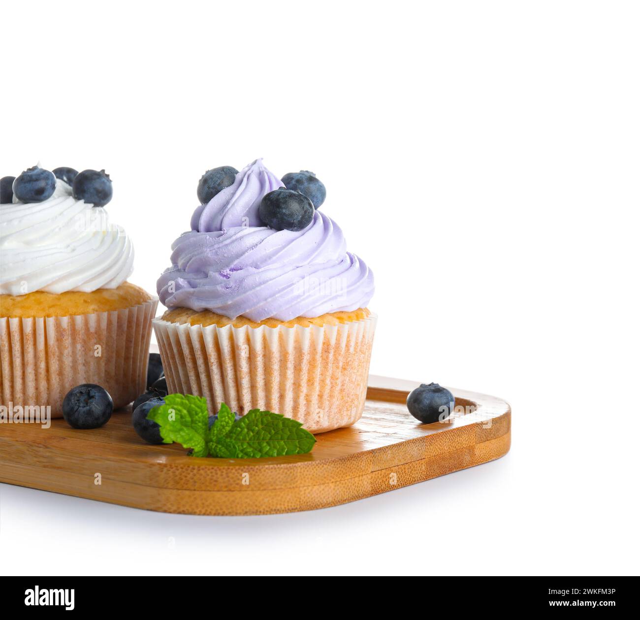 Holzbrett mit leckeren Cupcakes mit Heidelbeeren auf weißem Hintergrund Stockfoto