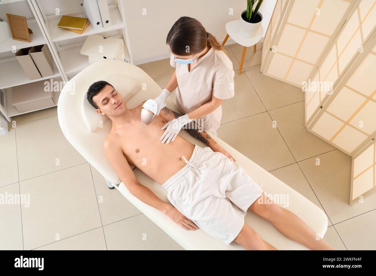 Kosmetiker mit Photoepilierer zur Haarentfernung im Schönheitssalon, Draufsicht Stockfoto