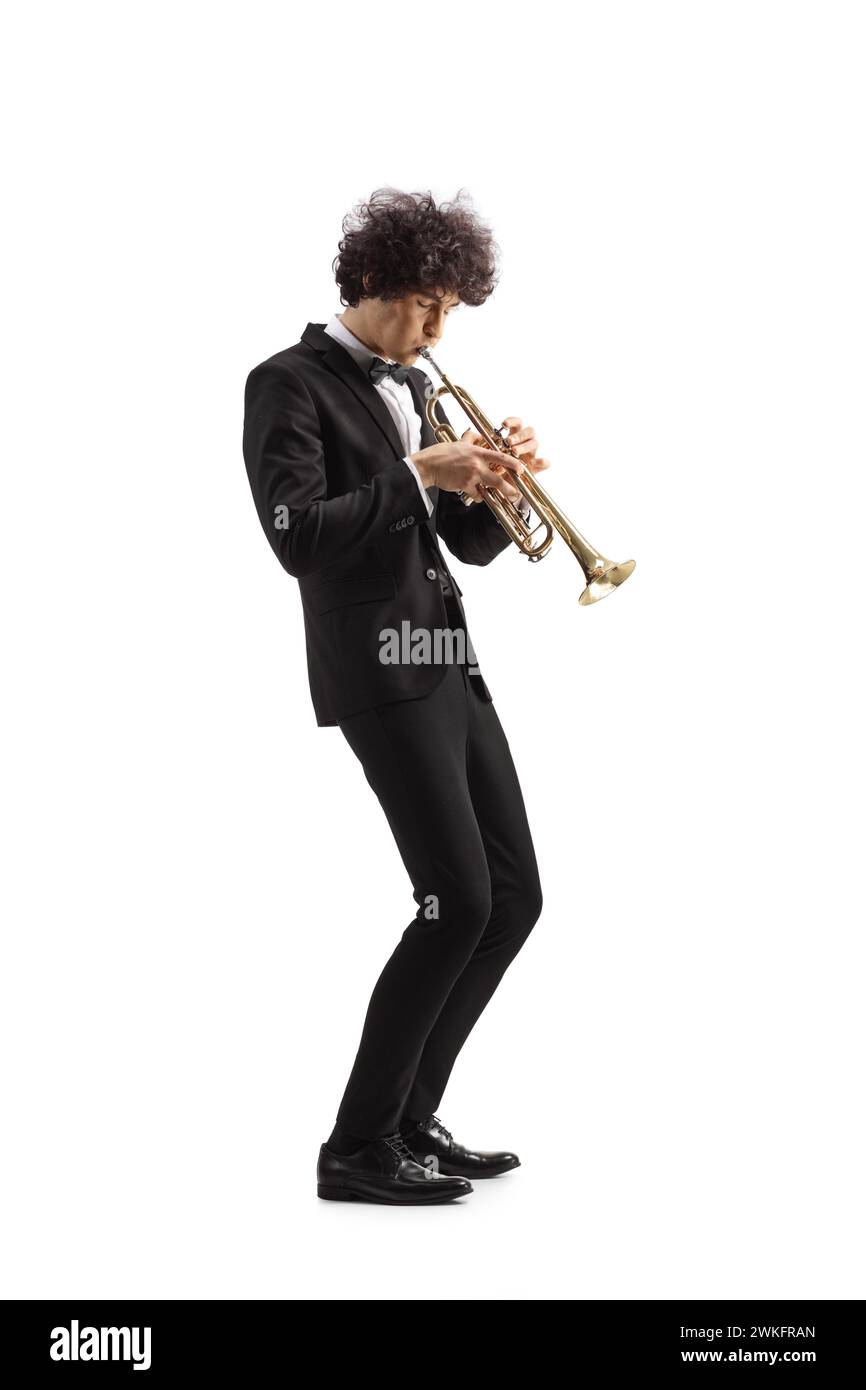 Junger männlicher Musiker in einem schwarzen Anzug, der eine Trompete auf weißem Hintergrund spielt Stockfoto