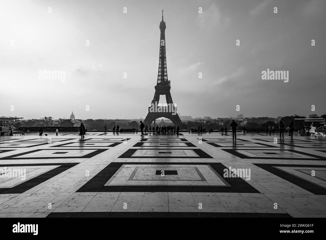 Eiffelturm, Französisch: Eiffelturm, Silhouette bei Sonnenaufgang. Blick vom Trocadero-Platz mit geometrischem Marmorpflaster. Paris, Frankreich. Schwarzweißfotografie. Stockfoto