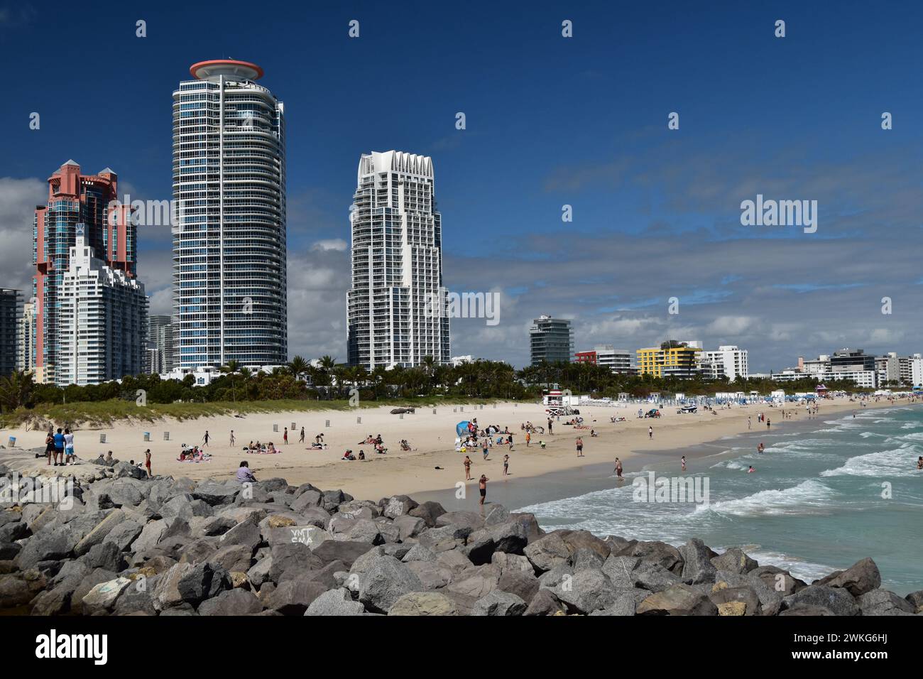Die Leute genießen einen sonnigen Februartag am South Pointe Beach, Miami Beach, Florida, mit Blick auf den Portofino Tower und den North & South Continuum Tower. Stockfoto