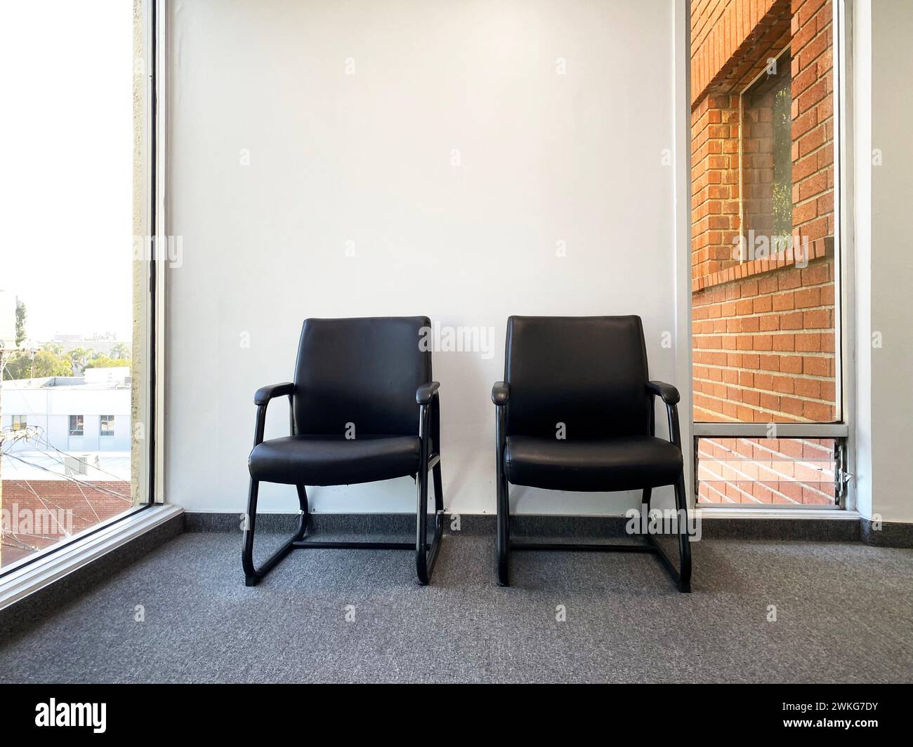 Zwei leere Stühle vor der Arztpraxis, der Zahnarztpraxis oder dem Wartezimmer eines Therapeuten Stockfoto
