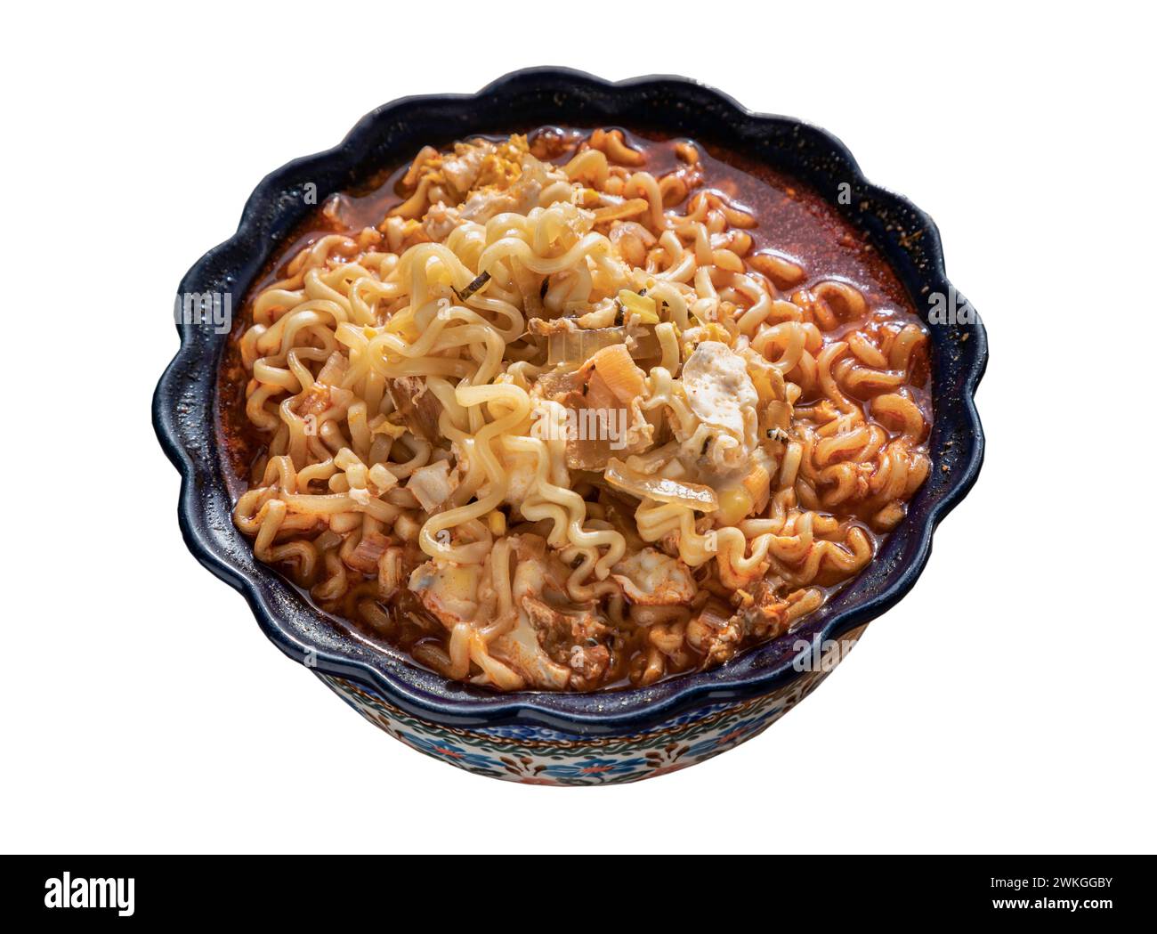 Scharfe tom Yum Instant-Nudeln mit Ei belegt und in Scheiben geschnittene ​​shallots in einer Keramikschale isoliert auf weißem Hintergrund mit Schneidepfad. Einfache Nudelgerichte, Stockfoto