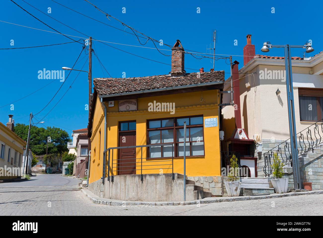 Kleines Haus mit orangefarbener Fassade und Holzfenstern in einer ruhigen Straße, Soufli, Ostmakedonien und Thrakien, Griechenland Stockfoto