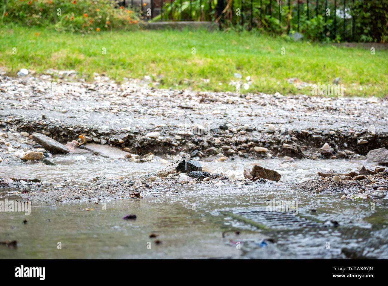 Schotterstraße in einer Gegend, die vom Regen durchbrochen wurde. Stockfoto