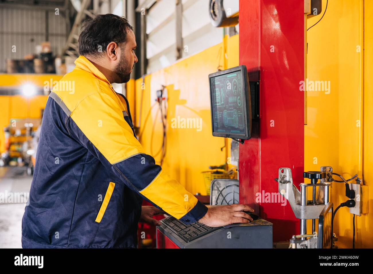 Mechaniker männlicher Arbeiter mit fortschrittlicher Computertechnik zur Tuning-Prüfung bei der Analyse von Autoproblemen in der Autosalon-Werkstatt Stockfoto
