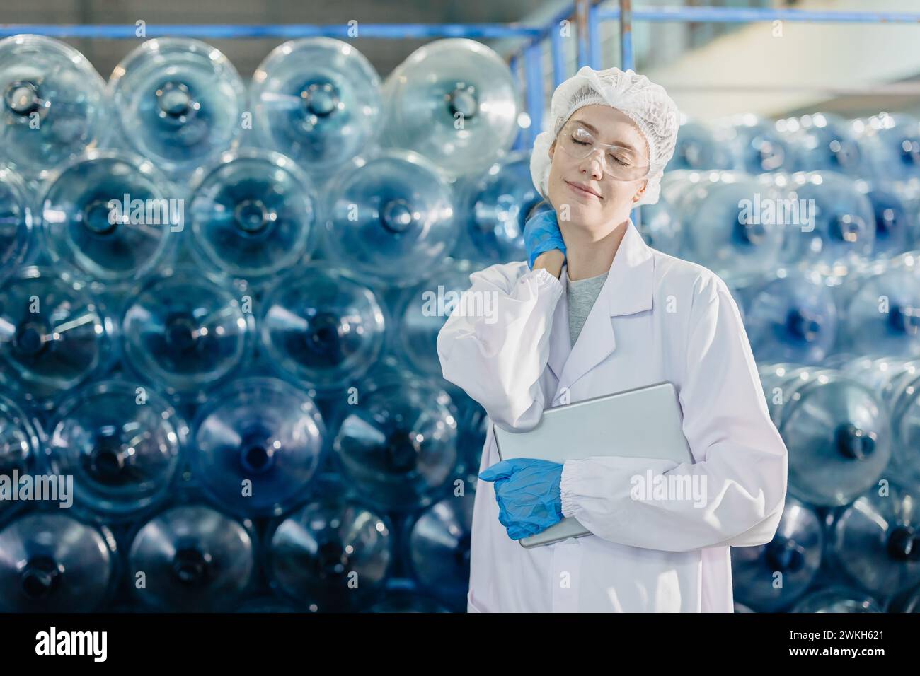 Erwachsene Frauen Bremse entspannen Arbeit in der Lebensmittel- und Getränkefabrik Trinkwasseranlagenarbeiter müde erschöpfte Geste. Stockfoto
