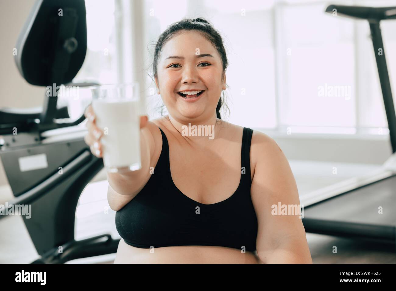 Sport gesunde fette Frauen glückliches Lächeln Genießen Sie trinken Milch und Diät Übung Aktivität in Fitness Sport Club Stockfoto