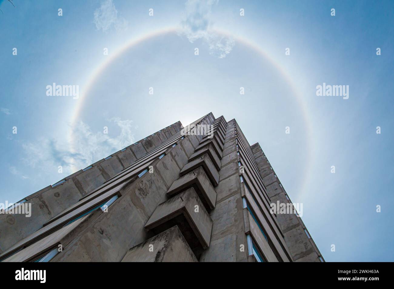 Sun Halo, Naturphänomen der sonnigen Lichtbrechung mit Wolken bis hin zu einem 360-Grad-Regenbogen mit Stadtgebäude Stockfoto