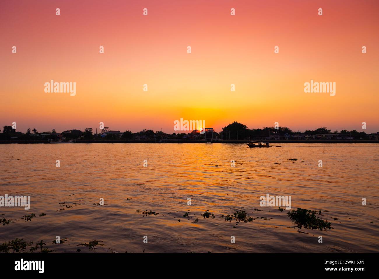Blick auf den Fluss bei Sonnenuntergang mit orangefarbenem Himmel. Abendliche Silhouette Boot ruhige ruhige Chaophraya Flusslandschaft Stockfoto