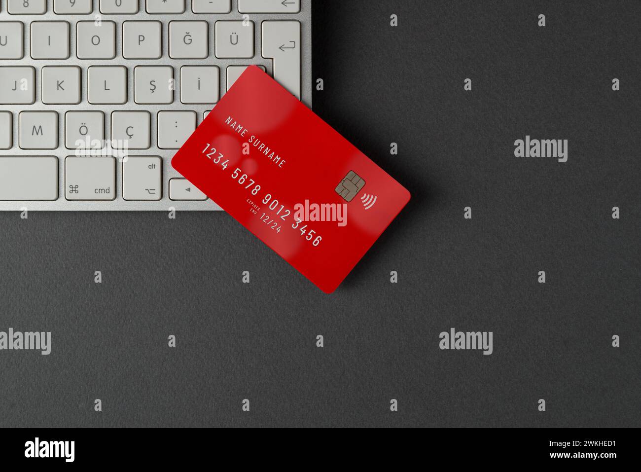 Draufsicht auf Computertastatur und Kreditkarte auf dunkelgrauem Tisch Stockfoto