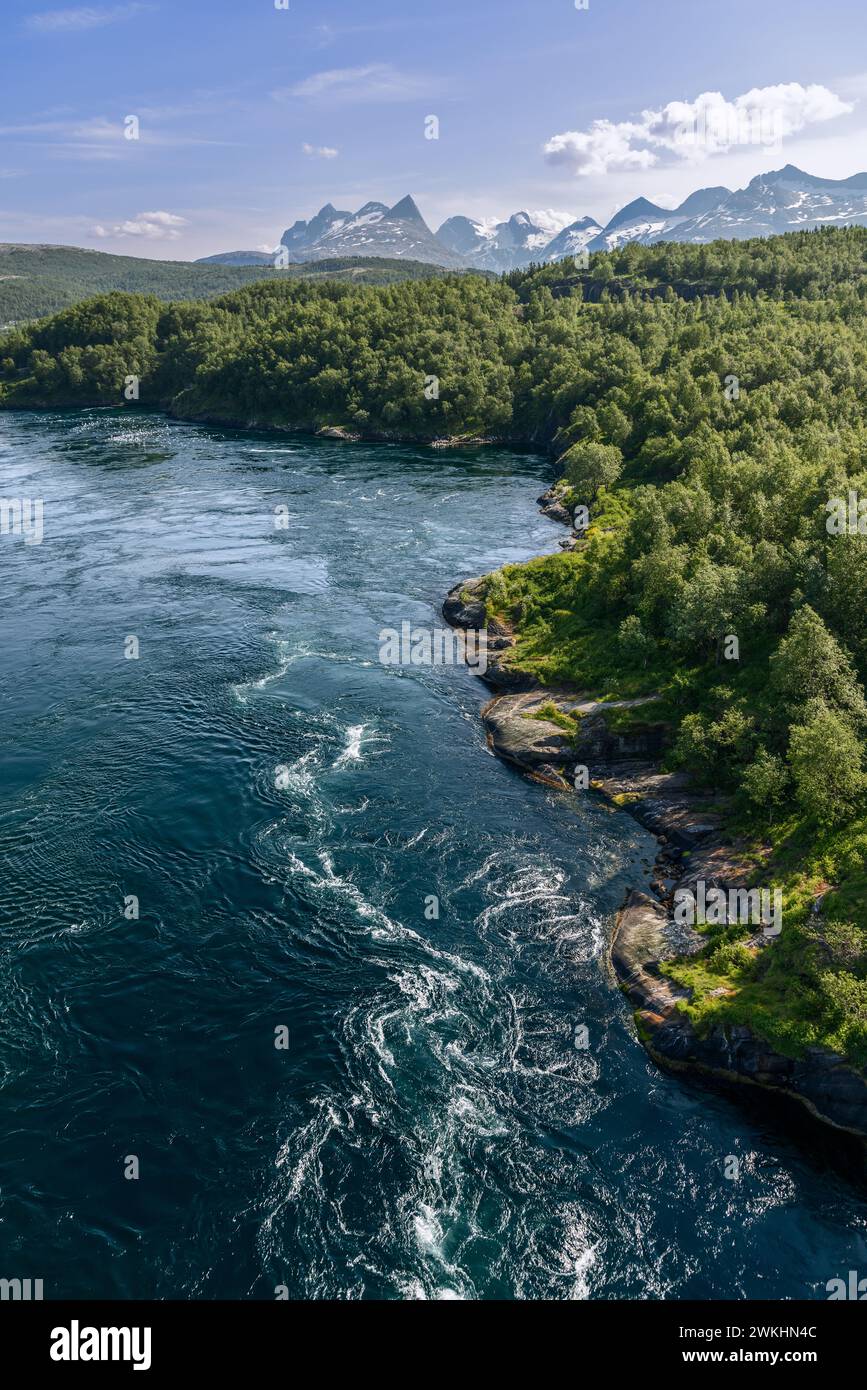 Die in einem vertikalen Rahmen eingefangenen Saltstraumen-Gezeitenströmungen wetten mit markanten Texturen und Schattierungen, die sich von der üppigen Landschaft abheben Stockfoto