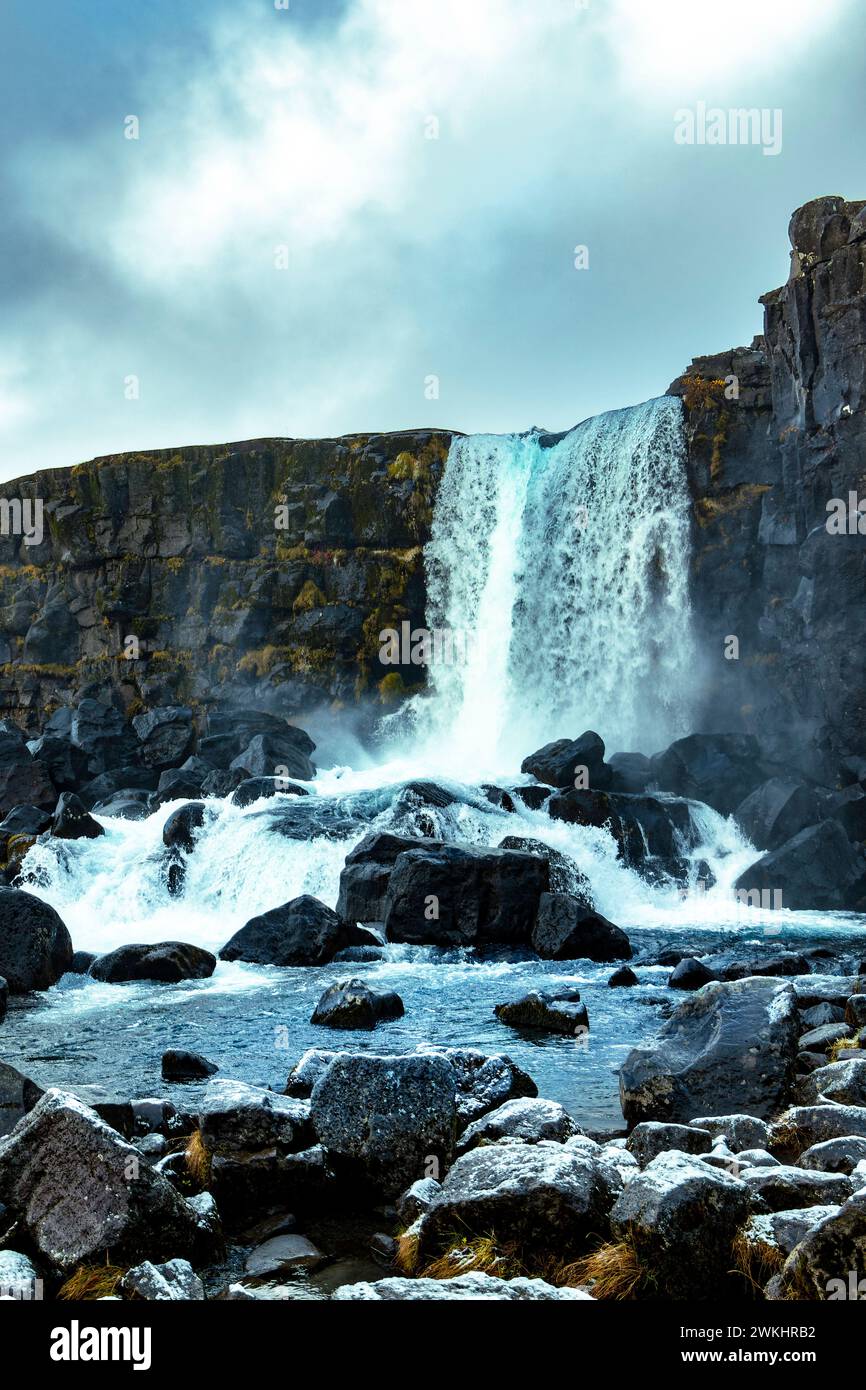 Malerischer Blick auf den milchweißen, schaumigen Wasserfall, der von der Spitze des felsigen Hügels und durch raue, scharfkantige Steine in bergigem Gelände fließt Stockfoto