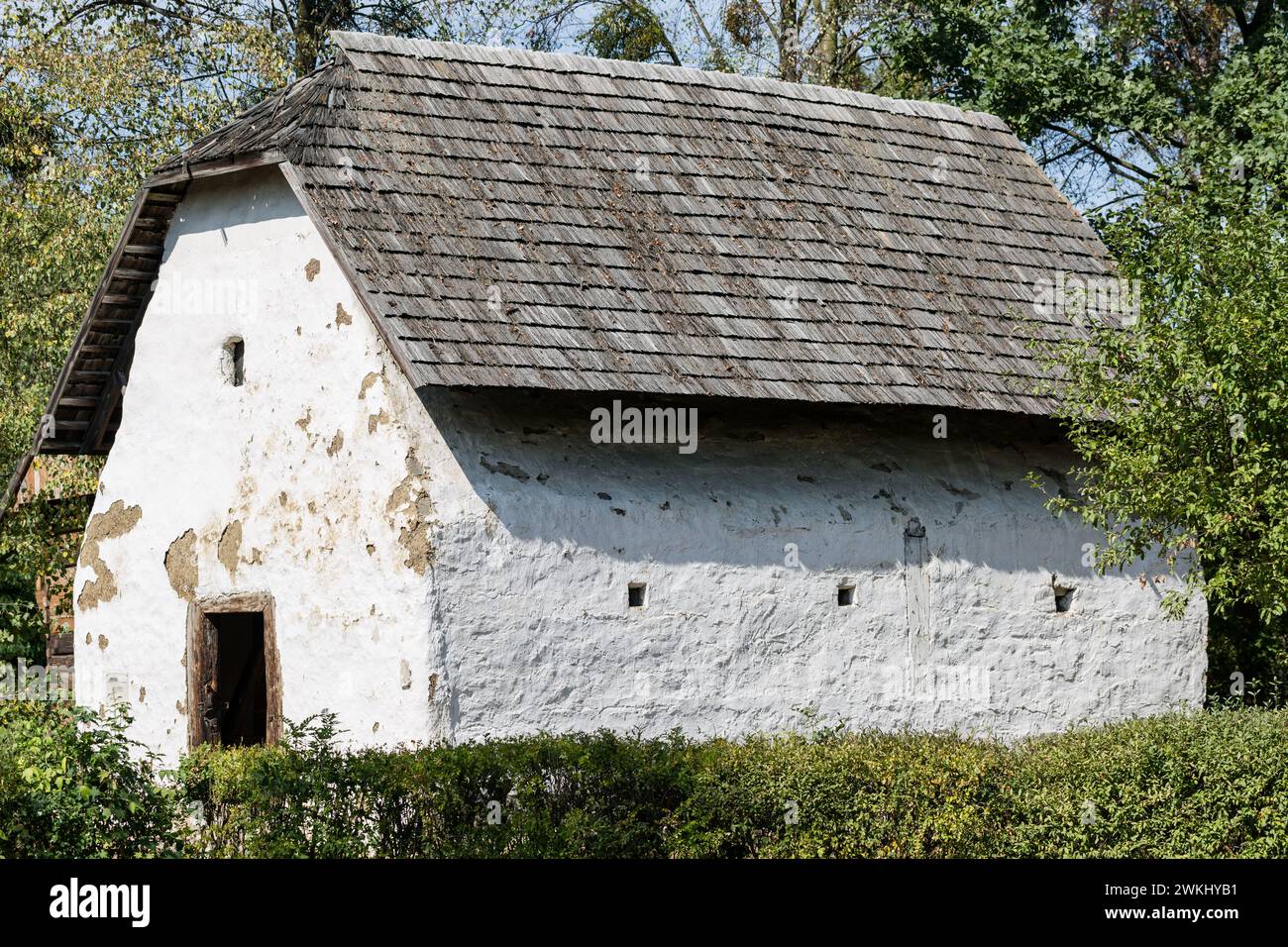 Alte Kornkammer im polnischen Dorf mit Holzziegeldach und weißer Kalksteinfassade. Ehemaliges deutsches Dorf in der Region Oppeln, Polen Stockfoto