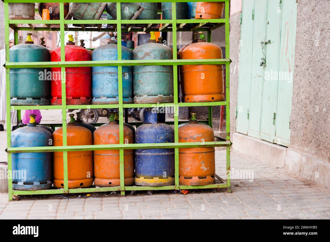 Farbenfrohe Propan-Butan-Gasflaschen auf Stahlregalen gelagert. Erdgasflaschen in einer Tankstelle in Marrakesch Marokko. Stockfoto
