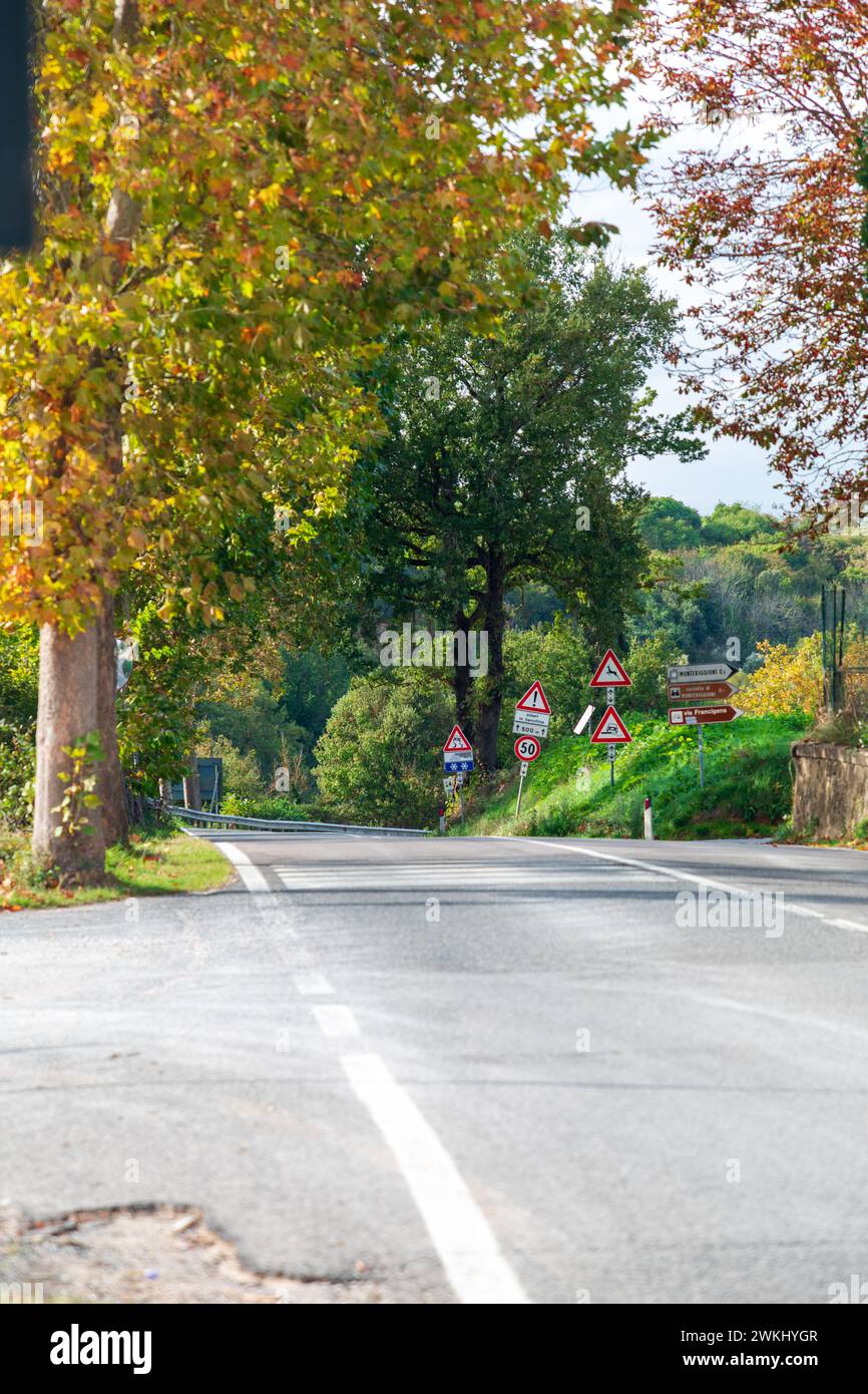 Asphaltstraße durch die ländliche Region der Toskana im Herbst. Richtung zum Schloss Monteriggioni. Stockfoto