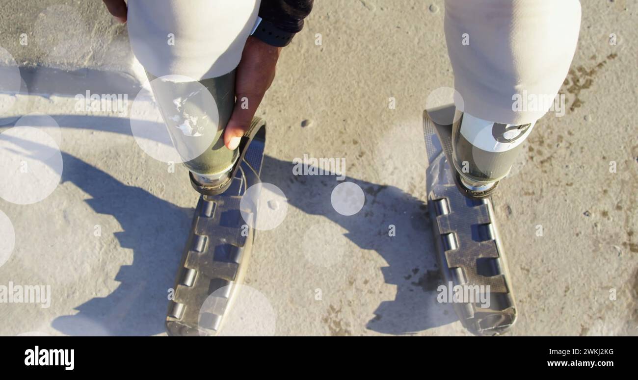 Bild von Lichtflecken über behinderten afroamerikanischen Frauen mit künstlichen Beinen Stockfoto