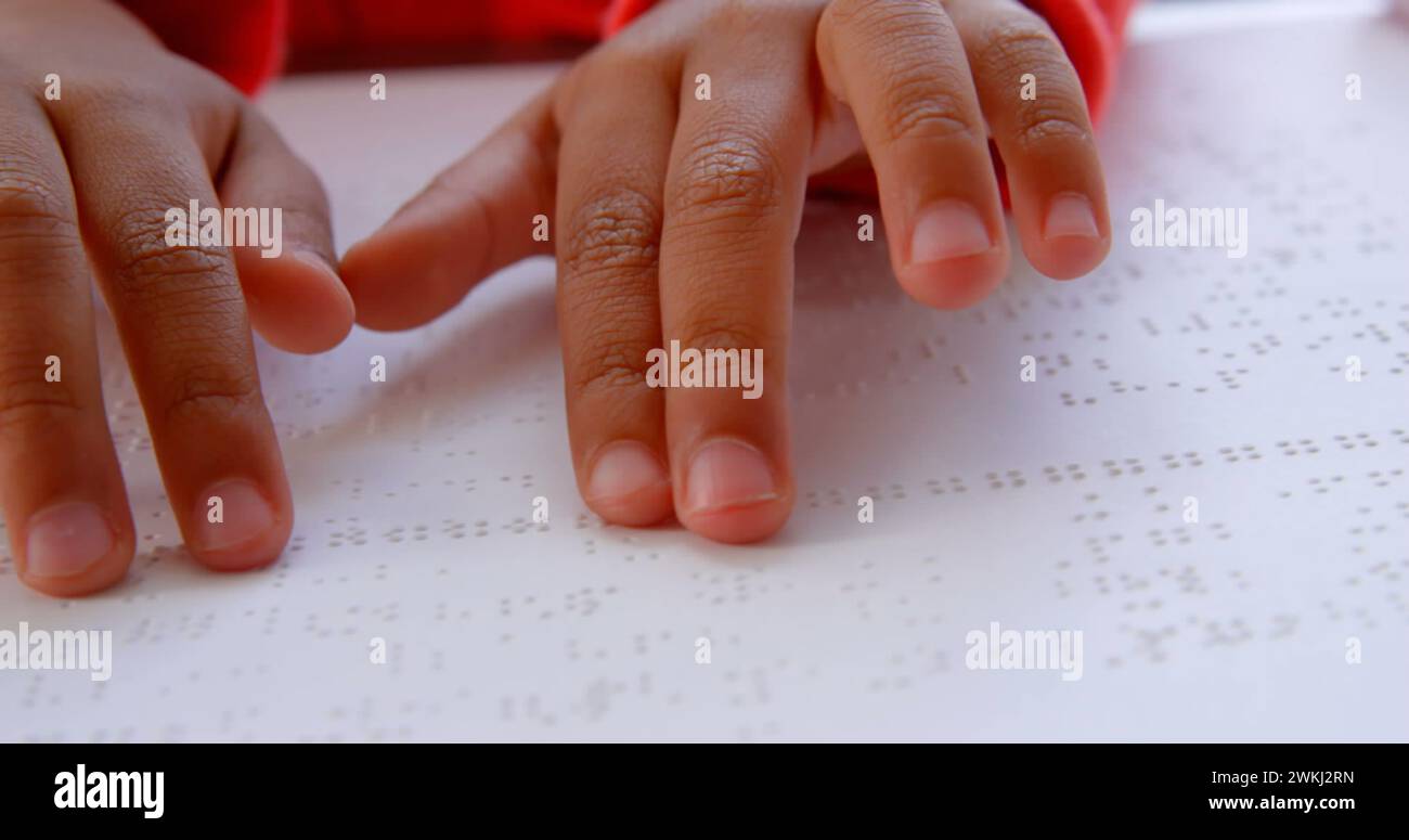 Die Hände des birassischen Jungen lesen Braille-Text, mit Kopierraum Stockfoto