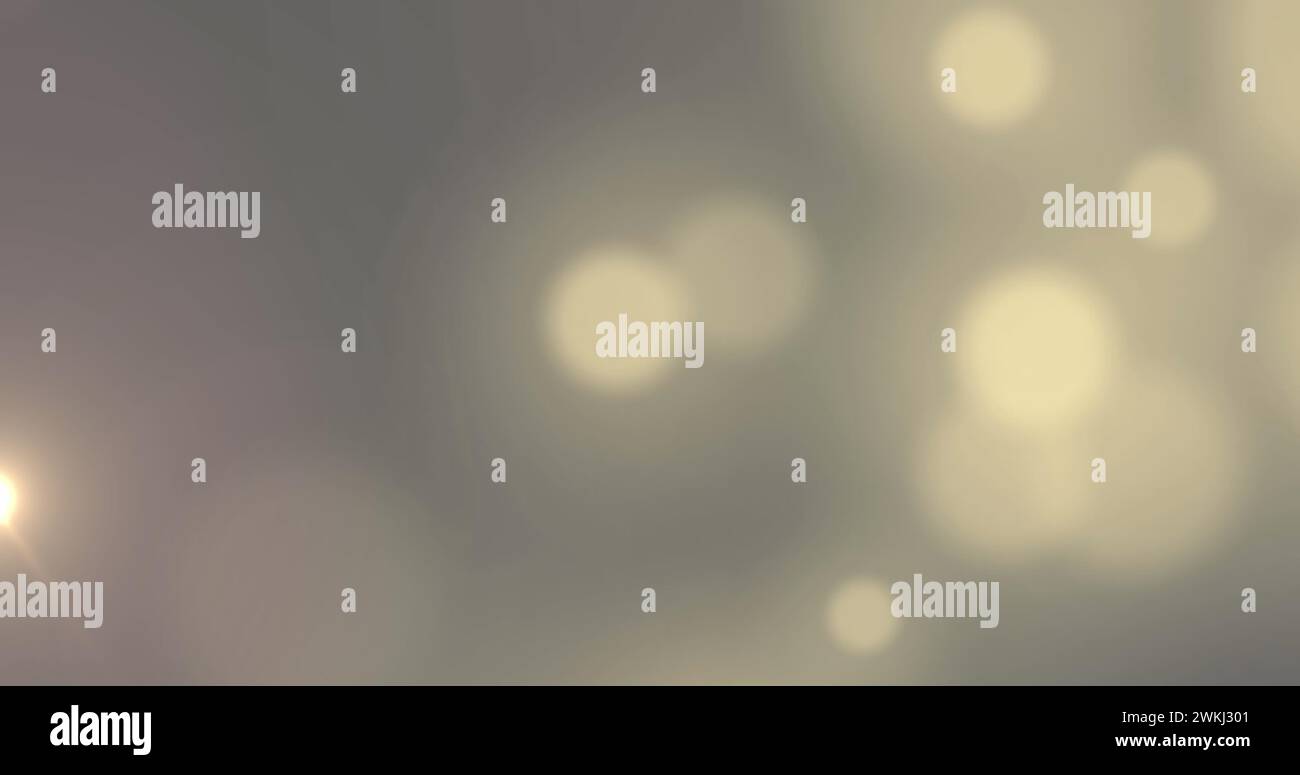 Bild von weißen Bokeh-Lichtflecken, die sich über grauem Hintergrund bewegen Stockfoto