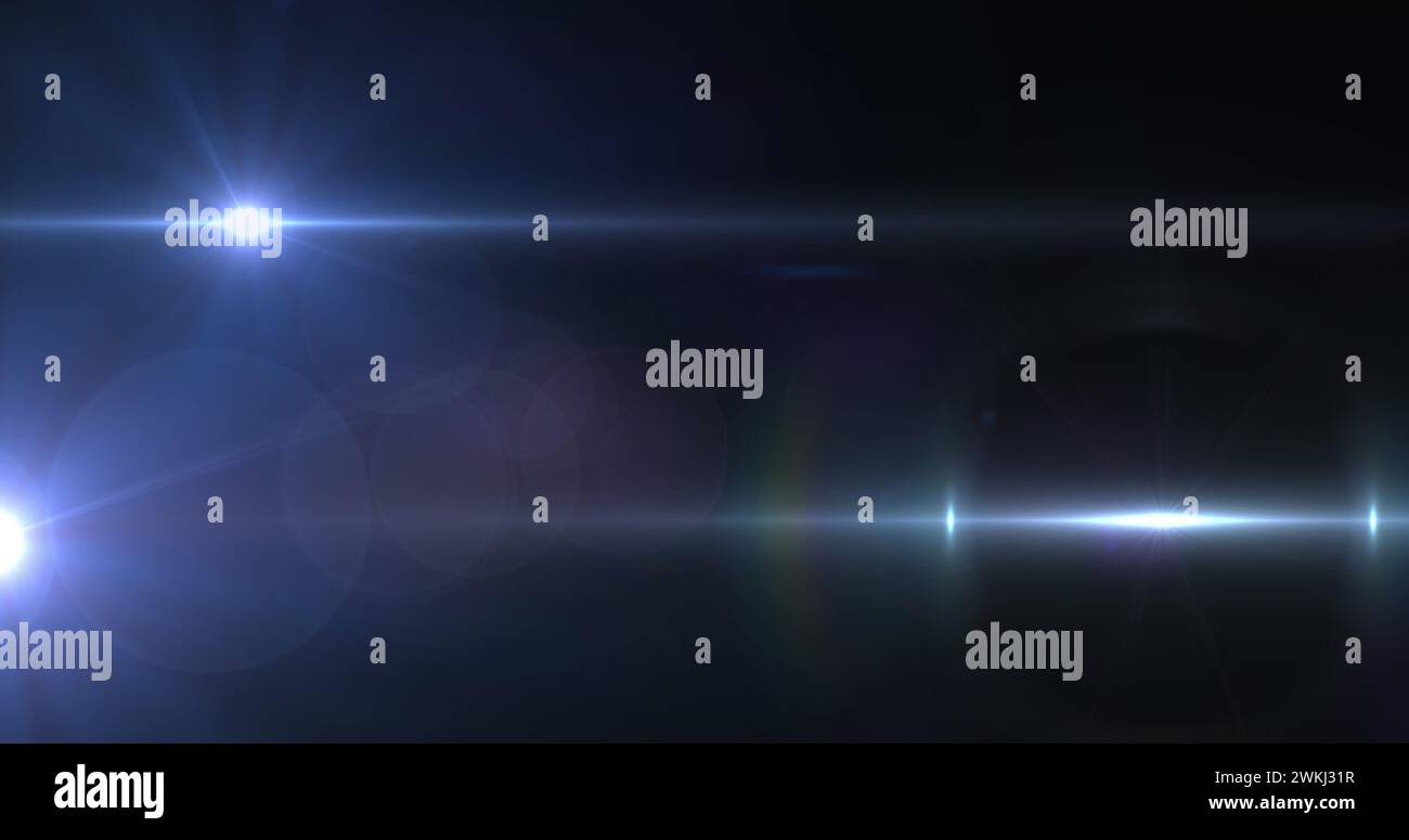 Bild eines Scheinwerfers mit Streulicht und Lichtstrahlen, die sich über einen dunklen Hintergrund bewegen Stockfoto