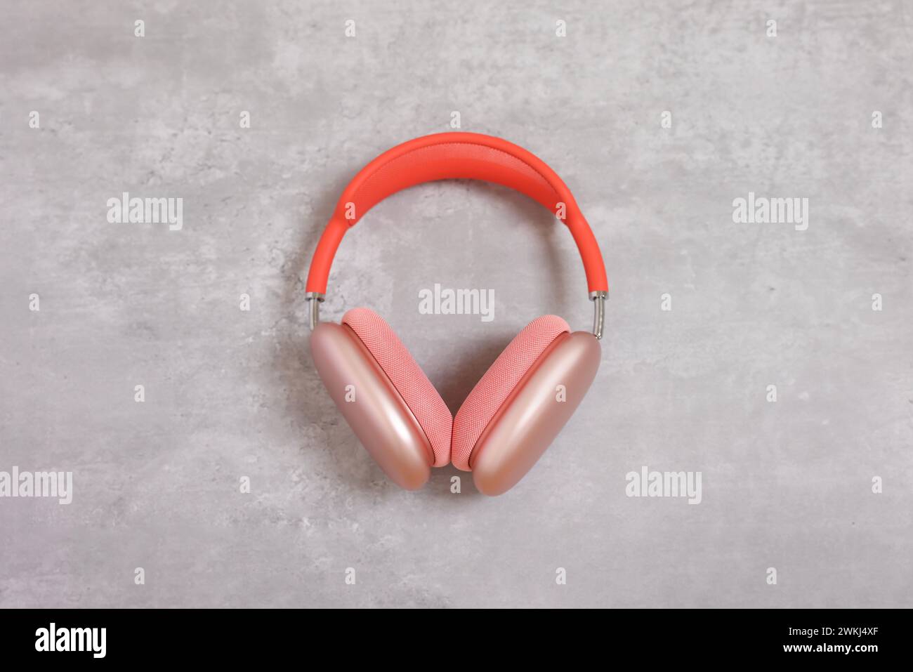 Elegante pinkfarbene Kopfhörer auf hellgrauem Tisch, Draufsicht Stockfoto