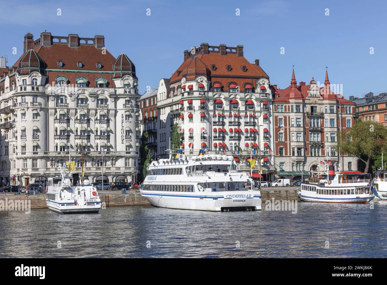 Historische Gebäude am Strandvagen 7 sind das Hotel Esplanade (l) und das Hotel Diplomat (r) hinter Booten und Fähren in Nybroviken, Ostermalm, Stockholm Stockfoto
